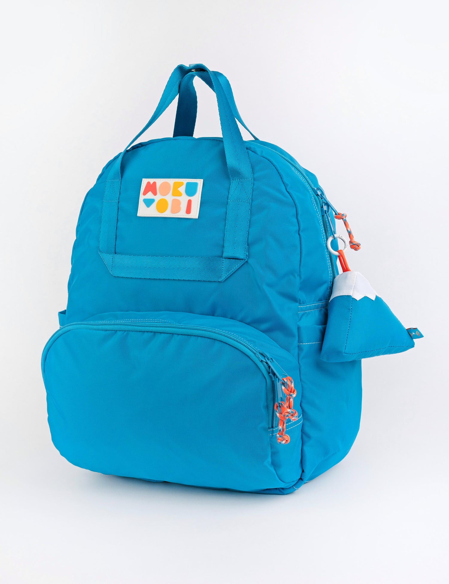 An aqua blue colored backpack with a mountain keychain accessory