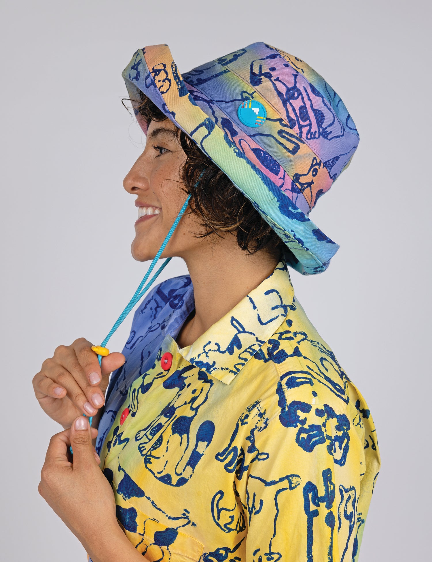 woman wearing a bucket style colorful hat with dog prints all over.