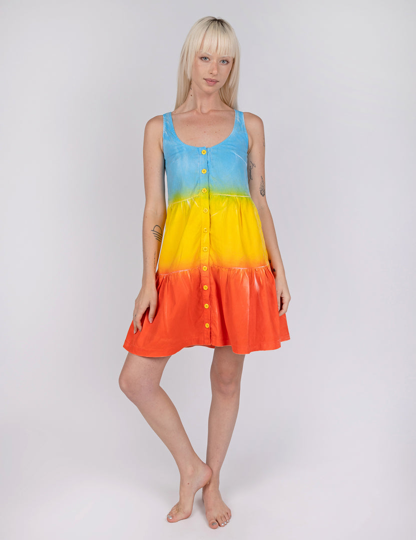 woman wearing tier style dress in gradient design of blue yellow and red orange