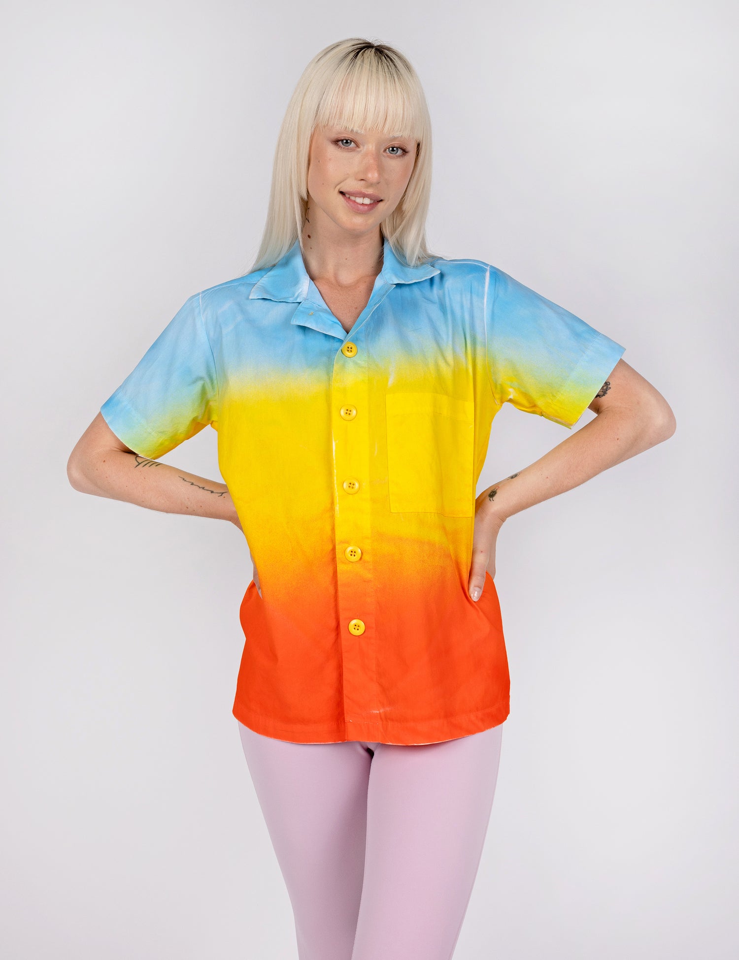 woman wearing a button down shirt in gradient designs of blue yellow and red orange