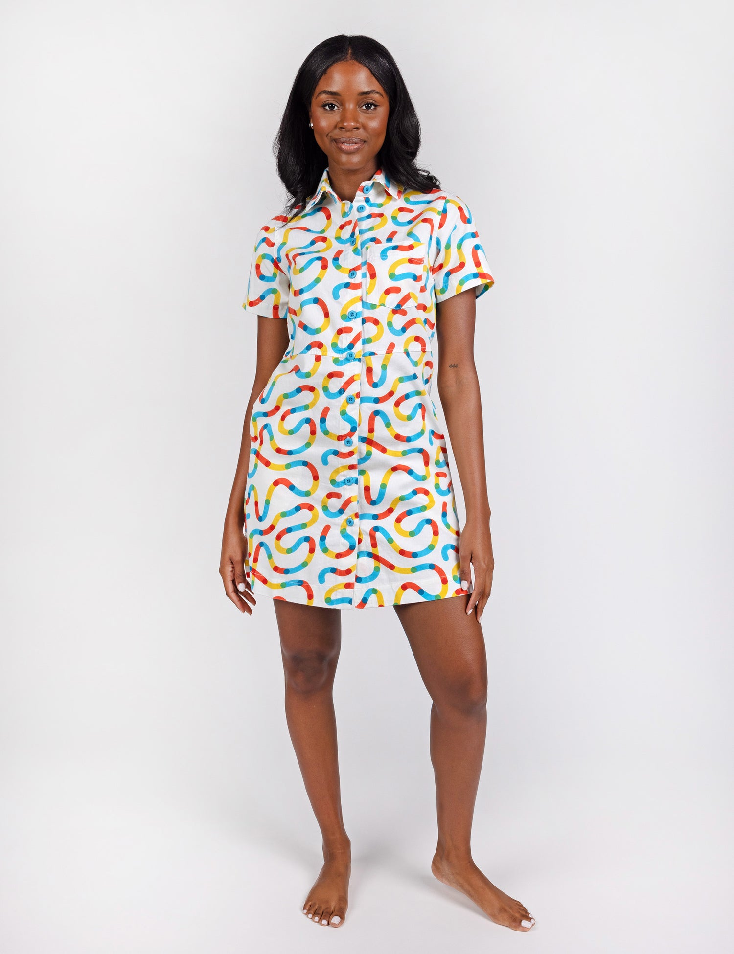 woman wearing a white button up dress with colorful squiggle designs