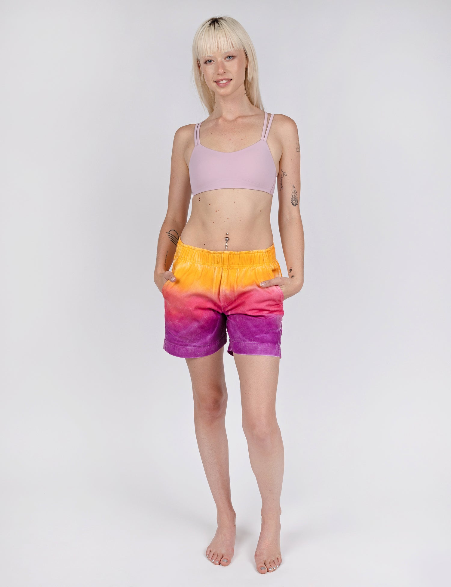 woman wearing relax fit shorts with gradient design of yellow pink and purple.