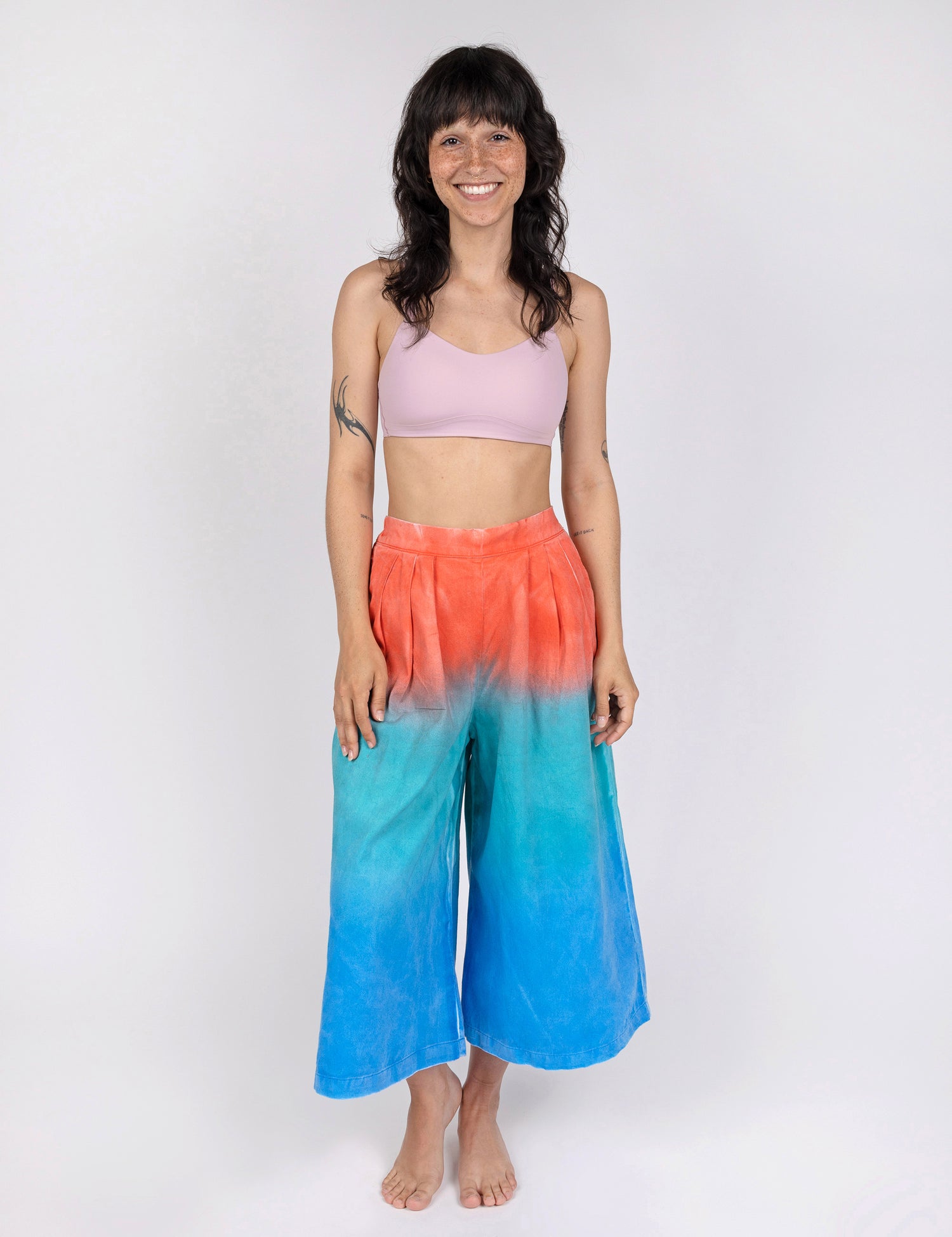 woman wearing culotte pants in gradient design of red teal and blue