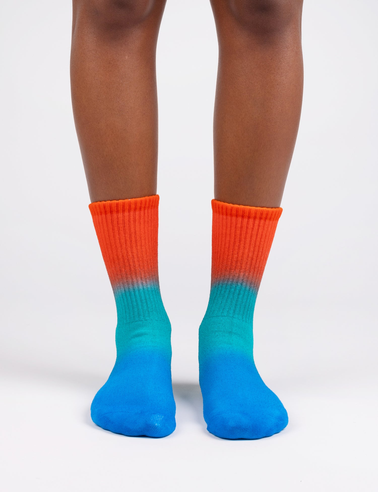 Image of feet wearing socks in gradient colors red aqua blue