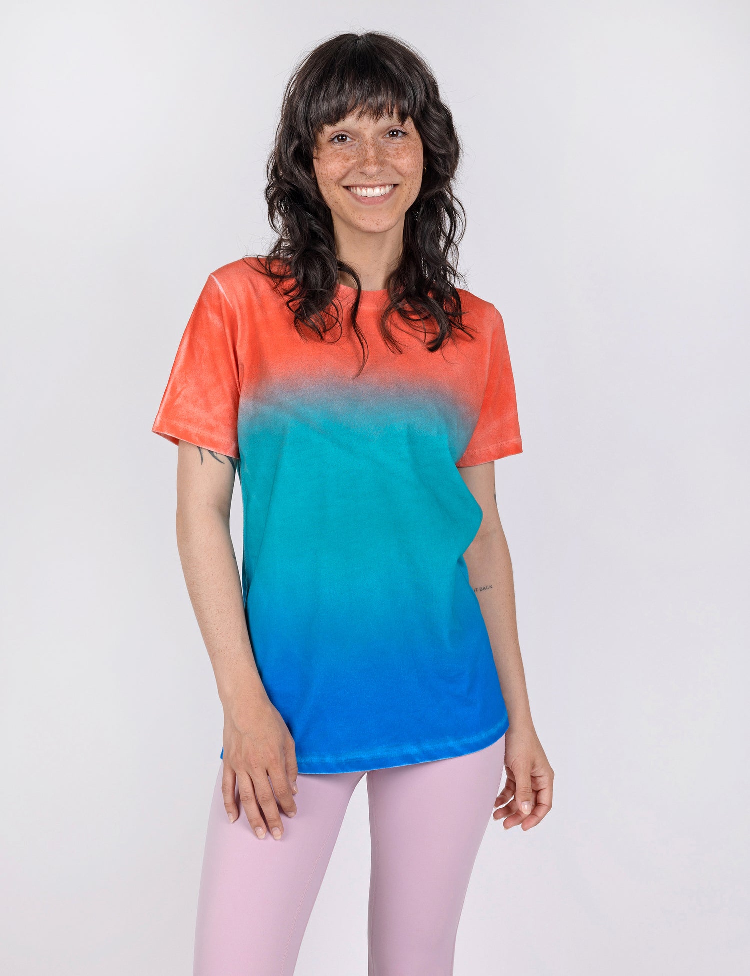 woman wearing a t shirt in gradient designs of red teal and blue