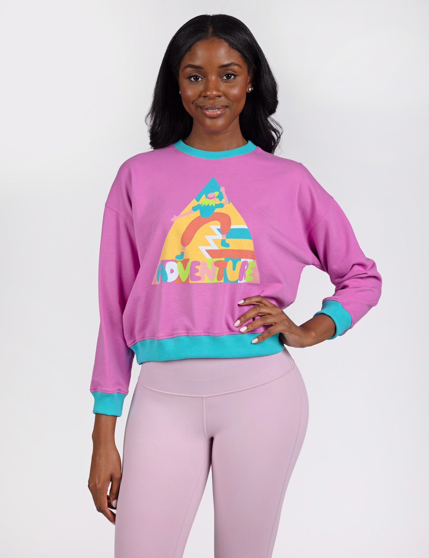 woman wearing a purple crop crew sweatshirt with colorful design in the middle