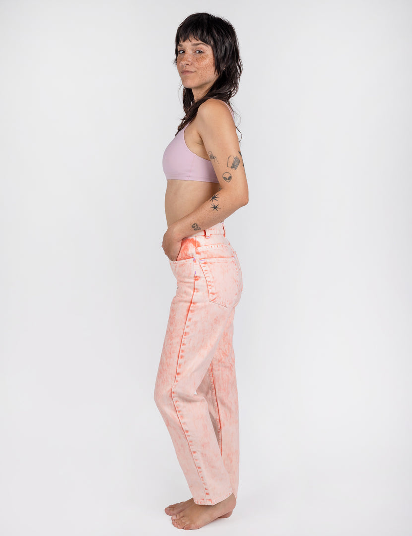side of a woman in light pink jeans 