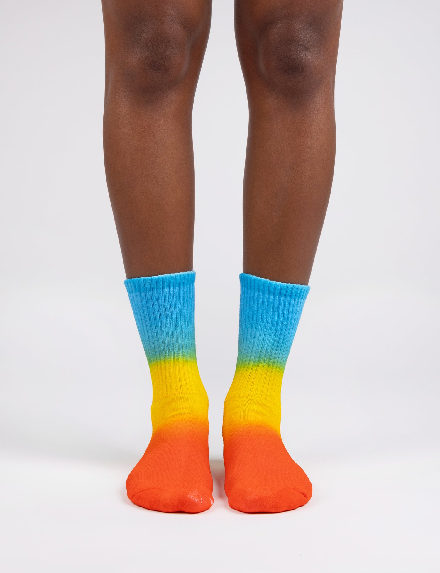 Image of feet wearing socks in gradient colors blue yellow orange