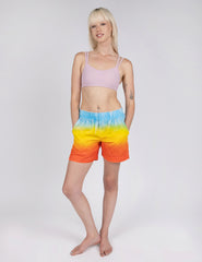 woman wearing relax fit shorts with gradient design of blue yellow and red orange.