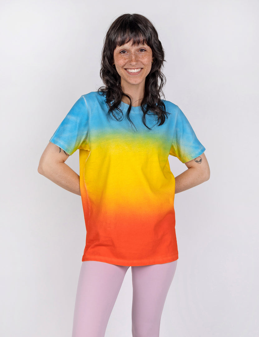woman wearing a t shirt in gradient designs of blue yellow and red orange.