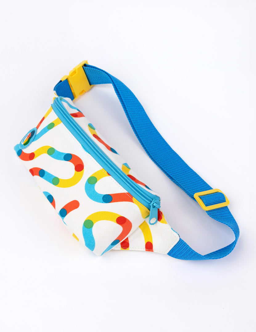 A small white fanny pack with colorful squiggles and blue strap