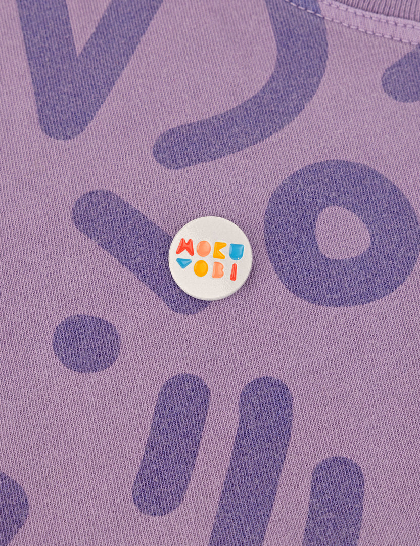  a enamel pin with the Mokuyobi logo on a Zap background