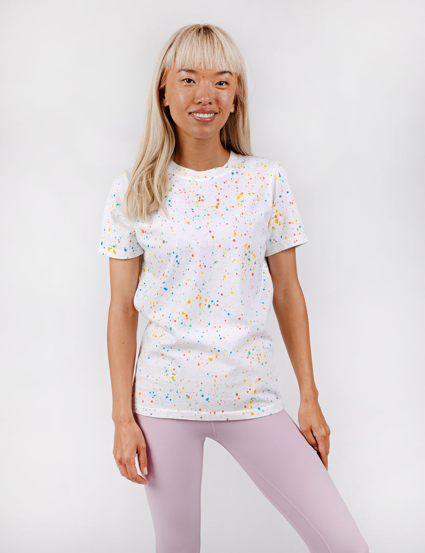 woman wearing all white tee with confetti paint all over