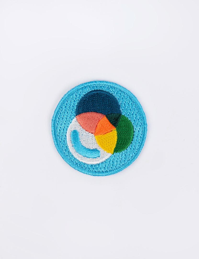 a blue circular patch with overlapping colorful prisms.