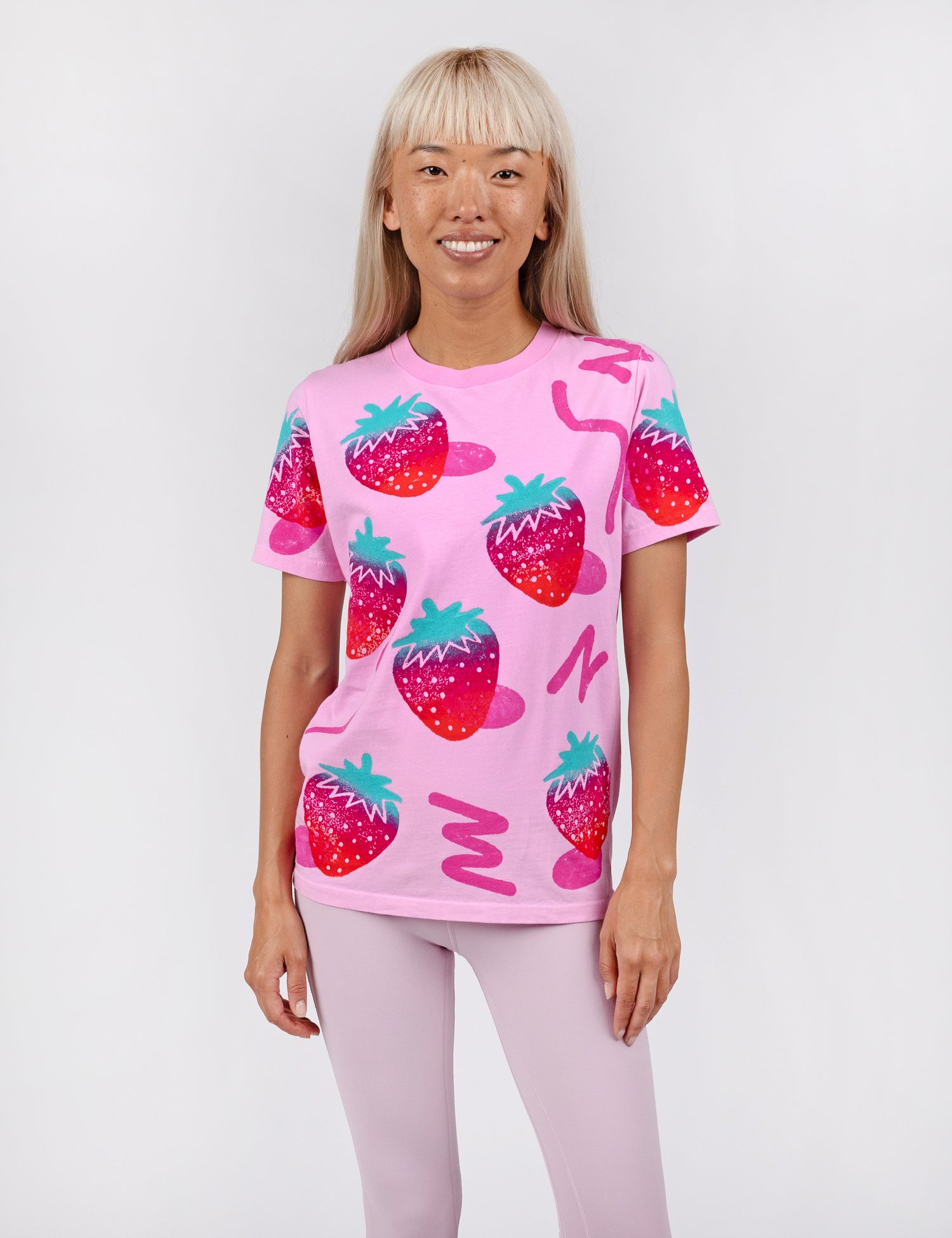 woman wearing a pink shirt with strawberry stamp print all over