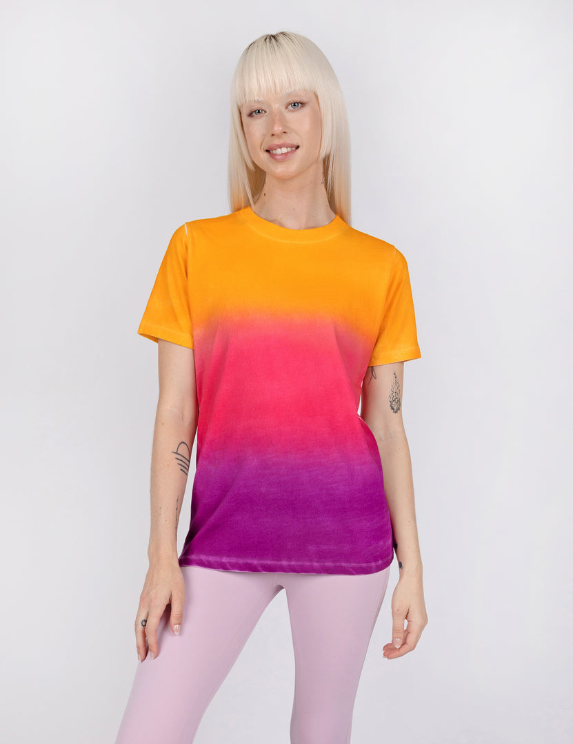 woman wearing a t shirt in gradient designs of yellow pink and purple.