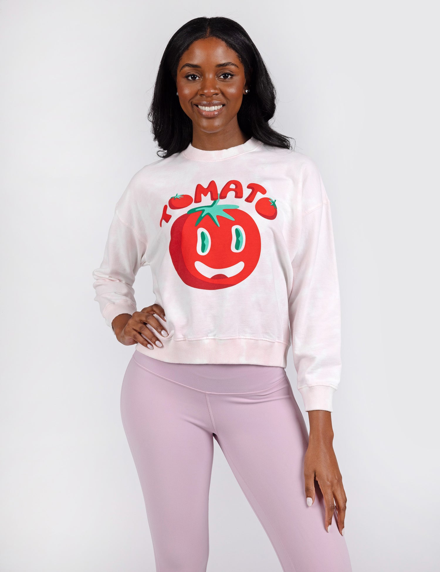 woman wearing white crop crew sweatshirt with red letters and tomato design