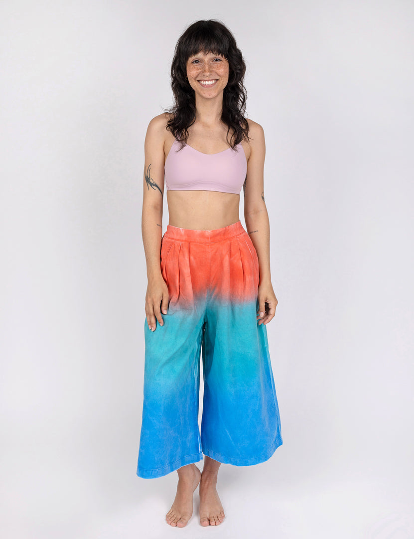 woman wearing culotte pants in gradient design of red teal and blue