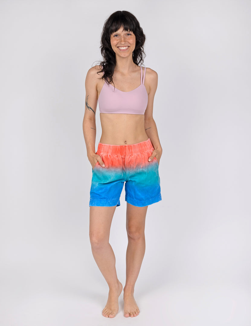 woman wearing relax fit shorts with gradient design of red teal and blue.